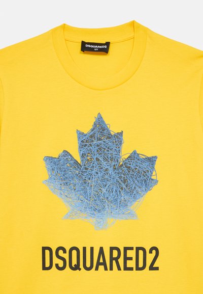 T-shirt en coton jaune avec un graphique bleu d'une feuille d'érable composée de bandes superposées, avec "DSQUARED2" imprimé en noir en dessous.
