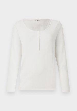White ribbed long-sleeve top with a round neckline and a partial button placket. Soft texture, fitted design, and minimalistic style.