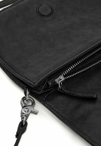 Borsa in pelle nera con superficie texturizzata, chiusura con zip e accessori in acciaio inox. Dotata di un gancio staccabile per una maggiore funzionalità.