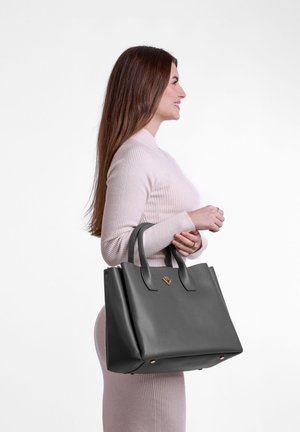 Šedá kožená taška přes rameno se strukturovaným designem, dvojitými uchy a diskrétním logem. Hladký povrch a lesklé provedení.