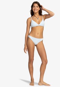 Svetlomodrý bikiny set s trojuholníkovým vrchom a nízko posadeným spodkom s károvaným vzorom. Vyrobené z hladkého syntetického materiálu.