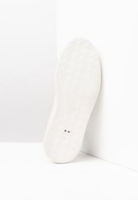 Suola di scarpa in gomma bianca con motivo di grip testurizzato. Presenta la bandiera italiana e la taglia "42" stampata sul fondo. Design pulito e minimalista.