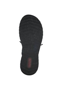 Suela de zapato de goma negra con un patrón de textura. Presenta un logotipo central y ranuras para tracción. Forma redondeada con ligera elevación del tacón.