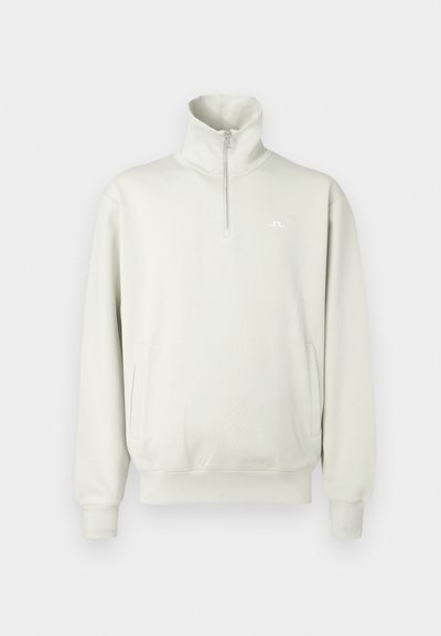 Απαλό γκρι μακρυμάνικο πουλόβερ με ψηλό γιακά, φερμουάρ μέχρ�ι το ένα τέταρτο, ριμπ μανσέτες και στρίφωμα, πλαϊνές τσέπες και μικρό λευκό λογότυπο στο στήθος.