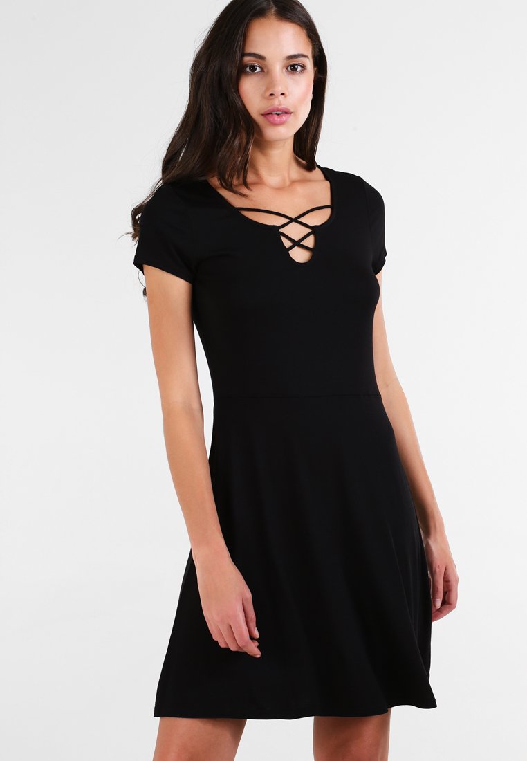 Czarna sukienka z krótkim rękawem o dopasowanej górze i rozkloszowanej spódnicy, z dekoltem w kształcie klucza i skrzyżowanymi detalami oraz gładką teksturą materiału.