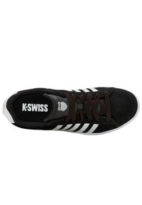 Zapatillas de ante negro con rayas y logotipo en blanco. Presenta un sistema de cordones plano y una lengüeta texturizada; suela de goma blanca lisa.