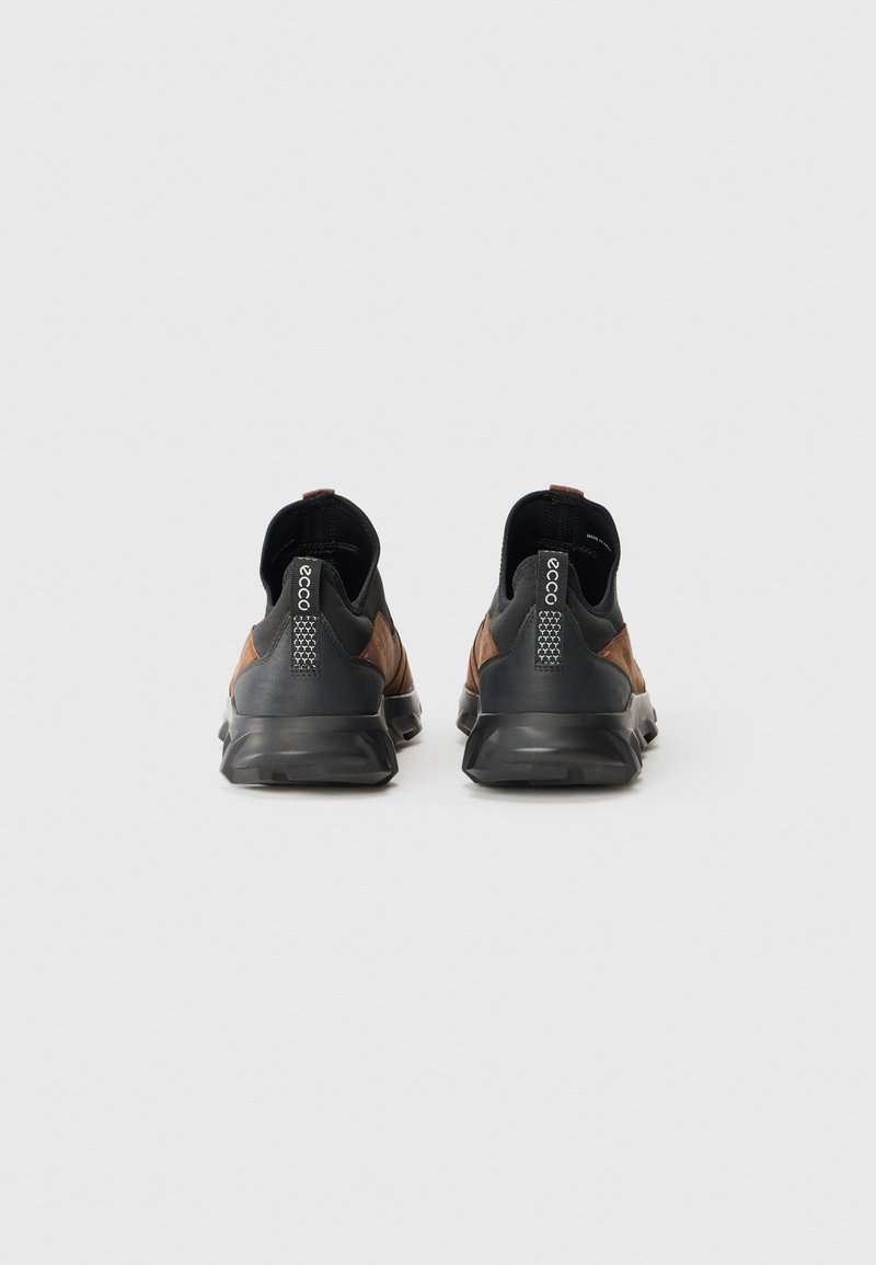 Schwarze und braune Sportschuhe mit einer strukturierten Oberseite, elastischen Einsätzen, Zuglaschen und einer dicken, flexiblen Sohle für Unterstützung.