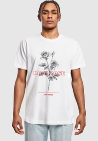 Bílý bavlněný tričko s černými ilustracemi růží a tučným červeným textem "IRON ROSE" a "RISE STRONG". Klasický design s kulatým výstřihem.