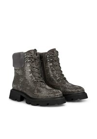 Bottes de randonnée gris métallisé avec une finition texturée, devant à lacets et fermeture éclair latérale. Col en fourrure et semelle noire épaisse. Accentué de clous.