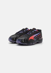 Zapatos deportivos negros con parte superior de malla, con acentos en rojo y púrpura, diseño de llamas único en los costados y suela de goma duradera.