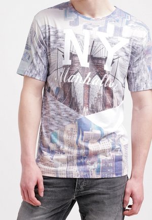 T-shirt à manches courtes avec un imprimé photoréaliste de la ligne d'horizon de New York, principalement en nuances de gris, avec le texte "NY Manhattan" affiché de manière proéminente.