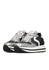 Sneaker con una toma in argento metallico e blu navy, con dettagli testurizzati neri, suole spesse bianche e stringhe a fantasia etichettate con testo.