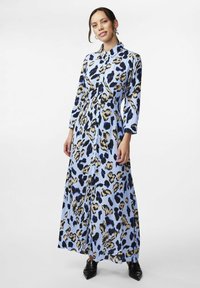Abito maxi blu con stampa leopardata nera e beige, caratterizzato da una chiusura a bottoni frontale e maniche lunghe. Tessuto dalla consistenza liscia.