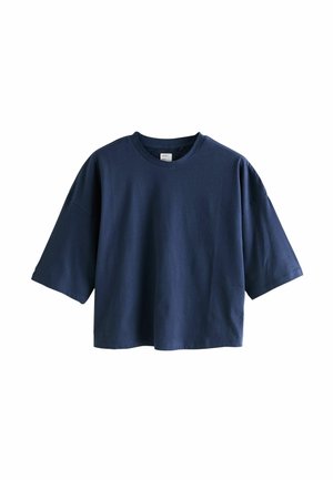 Granatowy, oversize’owy, skrócony t-shirt z krótkim rękawem, okrągłym dekoltem i luźnym krojem na białym tle.