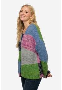 Kudotun kardiganissa on sininen, vihreä, vaaleanpunainen, harmaa ja musta osioiden sekoitus. Siinä on väljä leikkaus ja pitkät hihat, joissa on ribbireunat.