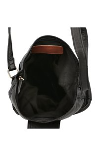 Borsa a spalla in pelle nera con una texture liscia, dotata di un ampio interno e di un accento in pelle marrone all'interno. Il design include una chiusura con zip.