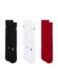Tre paia di calzini: neri con dettagli bianchi, bianchi con dettagli neri e rossi con dettagli neri. Tutti presentano una texture a coste e il logo.