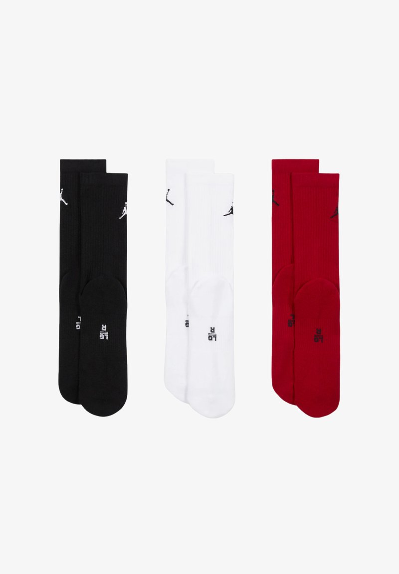 Tre paia di calzini: neri con dettagli bianchi, bianchi con dettagli neri e rossi con dettagli neri. Tutti presentano una texture a coste e il logo.