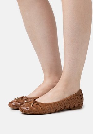 Ballerines en cuir tissé brun avec des orteils ronds, de petits nœuds à l'avant et une semelle plate sans détails matériels visibles.