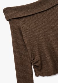 Brun, ribbet langærmet top med off-shoulder design, der har en foldet halsudskæring og diskrete syninger. Blød tekstur.
