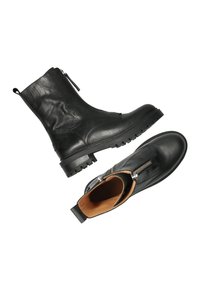 Zwarte leren enkellaarsjes met zijknopen, robuuste zolen en een gladde afwerking. Van binnen gevoerd met bruin suede, met een trek lus.