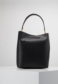 Sac seau en cuir noir avec anse courbée, poche avant carrée, accents en métal doré et texture lisse.