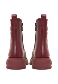 Stivali alla caviglia in pelle bordeaux con texture trapuntata, chiusura con cerniera e suola in gomma spessa. Presentano linguette per un facile indossamento.