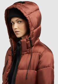 Puffer jacket in metallic rust color, featuring a quilted design, adjustable black drawstrings, and a high collar with a zip closure.