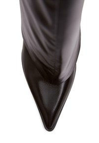 Stivale con punta appuntita in pelle nera, dalla texture liscia e dalla parte superiore aderente. La suola è elegante e affusolata, enfatizzando una silhouette moderna.