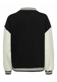 Czarny i kremowy sweter z kontrastowym wzorem rękawów, ribbowym dekoltem oraz paskowanymi mankietami. Materiał wydaje się miękki i teksturowany.