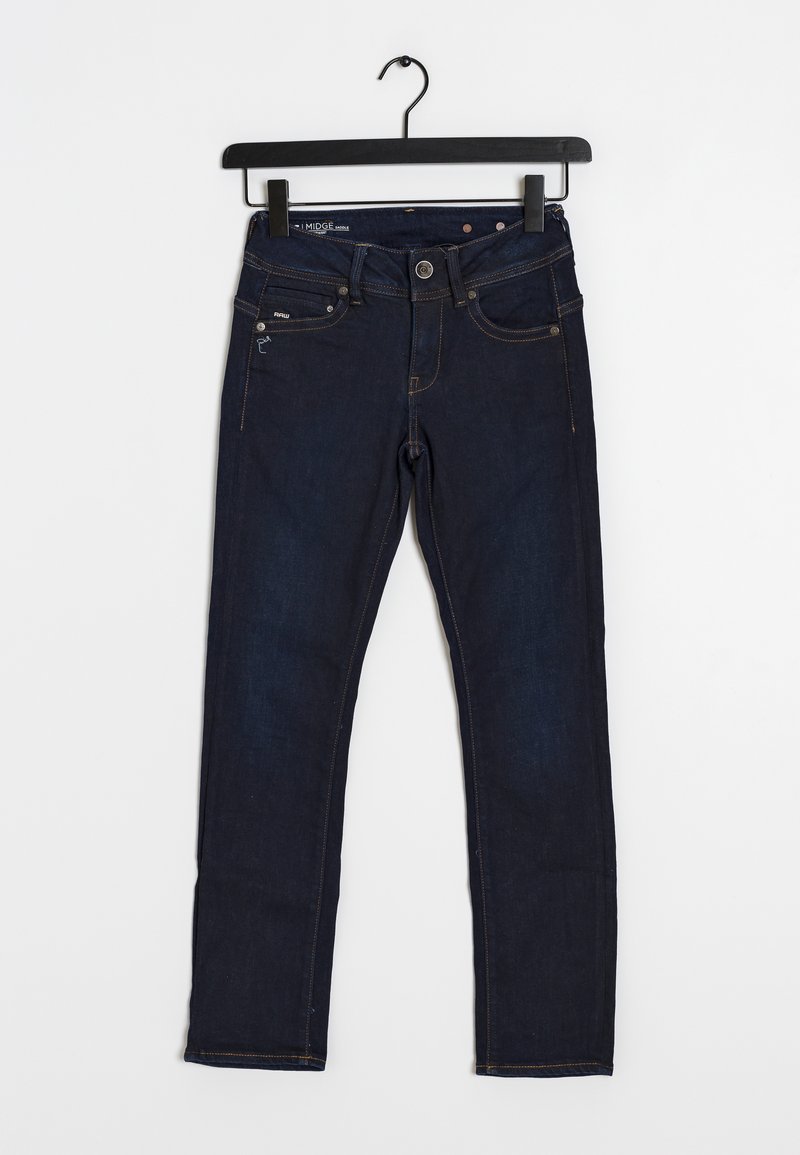 Jean slim en denim bleu foncé avec poches avant et fermeture par bouton, suspendu sur un cintre noir sur fond blanc.