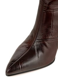 Damskie botki na obcasie w ciemnobrązowej skórze, z teksturowaną powierzchnią i widocznymi zagnieceniami oraz smukłym, wysokim obcasem.