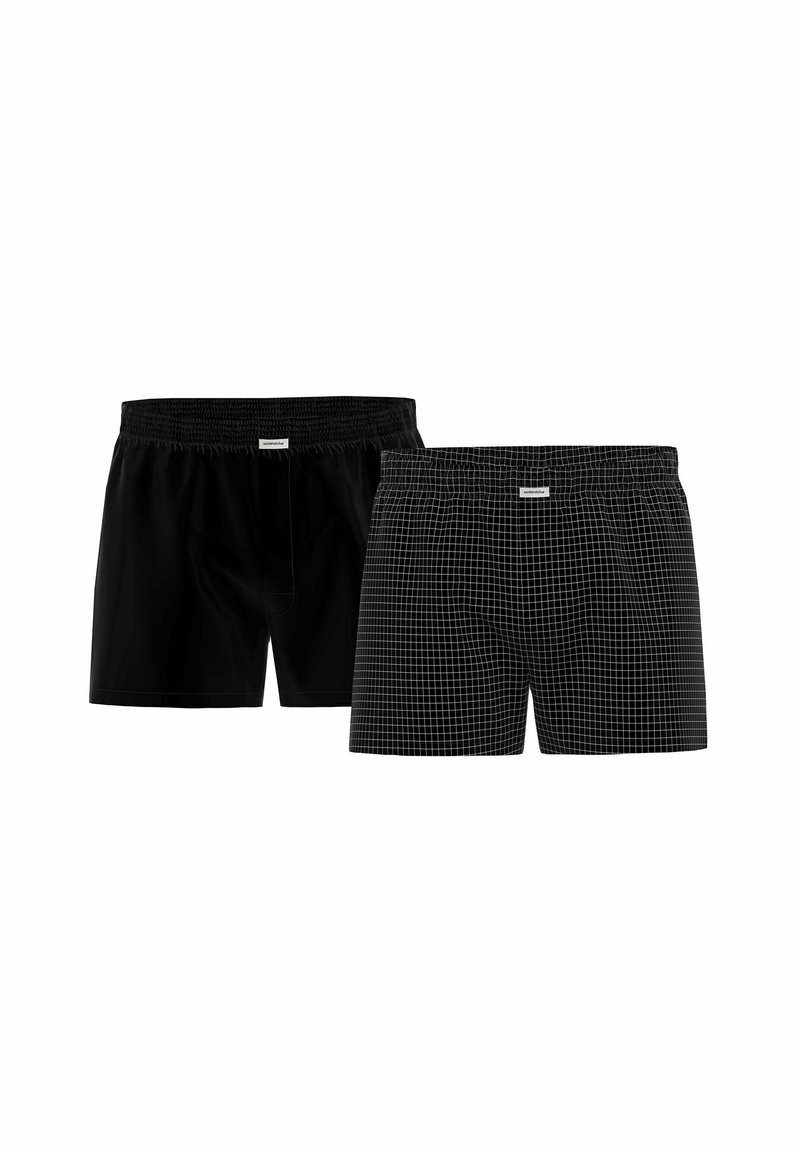 Two pairs of boxers: one solid black and one black with a white grid pattern, both featuring elastic waistbands and soft fabric.