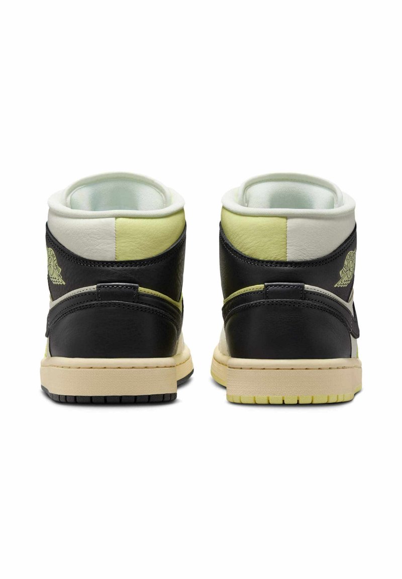 Zapatillas altas de cuero negro con acentos en amarillo y blanco, cuello acolchado, suela texturizada y logo icónico en la parte trasera.