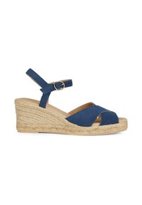 Sandalo con zeppa blu in suede, con punta aperta e cinturini incrociati. Presenta un cinturino alla caviglia con una fibbia dorata e una piattaforma avvolta in juta testurizzata.