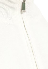 Valkoinen vetoketjullinen villapaita, joka on valmistettu pehmeästä kankaasta ja jossa on korkea kaulus, ribsikuvio ja erottuva metallivetoketjus yksityiskohta edessä.