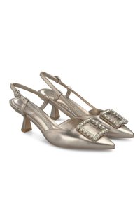 Metallic gouden slingback hakken met spitse neuzen, middelhoge blokhak en een decoratieve strass gesp op elke schoen.