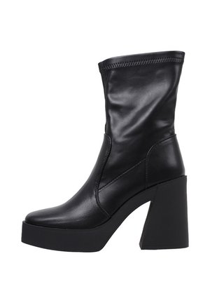 Botte en cuir noire mi-mollet avec un large talon bloc et une semelle plateforme, présentant des coutures détaillées le long du bord supérieur.