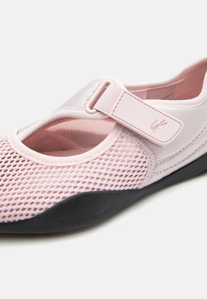 Scarpa Mary Jane in rete rosa chiaro con cinturino regolabile e suola nera, dettaglio ravvicinato della texture e della chiusura.