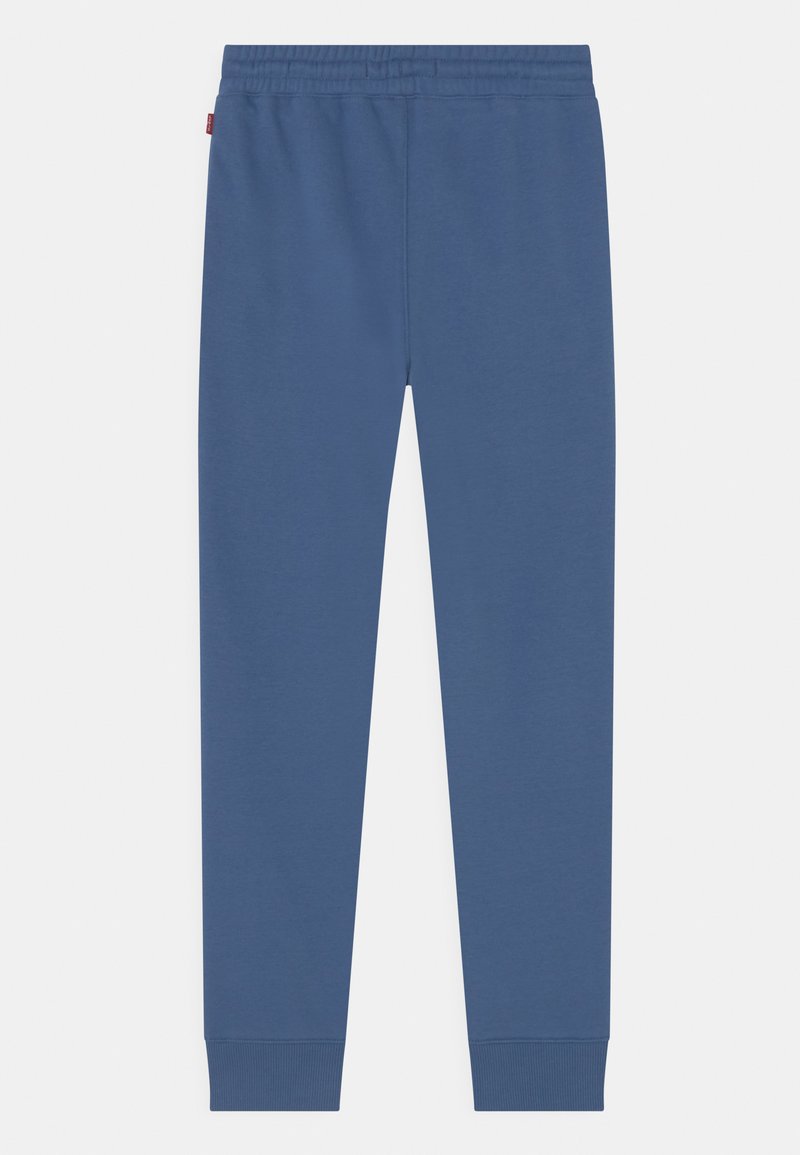 Pantalon de survêtement bleu en tissu doux, avec une taille élastique et des poignets côtelés aux chevilles, au toucher lisse sur l'ensemble.