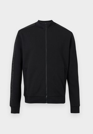 Black full-zip jacket with high collar, ribbed cuffs and hem, and subtle tonal logo detail on sleeves.