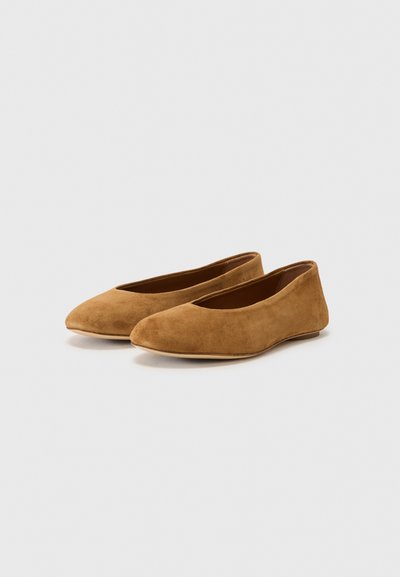 Bailarinas de ante en un tono marrón cálido, con diseño de punta afilada y una textura suave y lisa. Suela plana con un estilo minimalista.