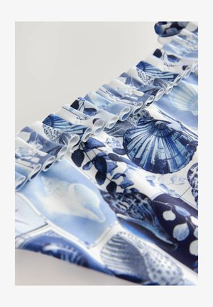 Sininen ja valkoinen kangas, jossa on simpukkakuosi. Repaleiset reunat luovat tekstuuria, ja kankaassa on yksityiskohtaisia kuvia simpukoista ja kasvi-elementeistä.