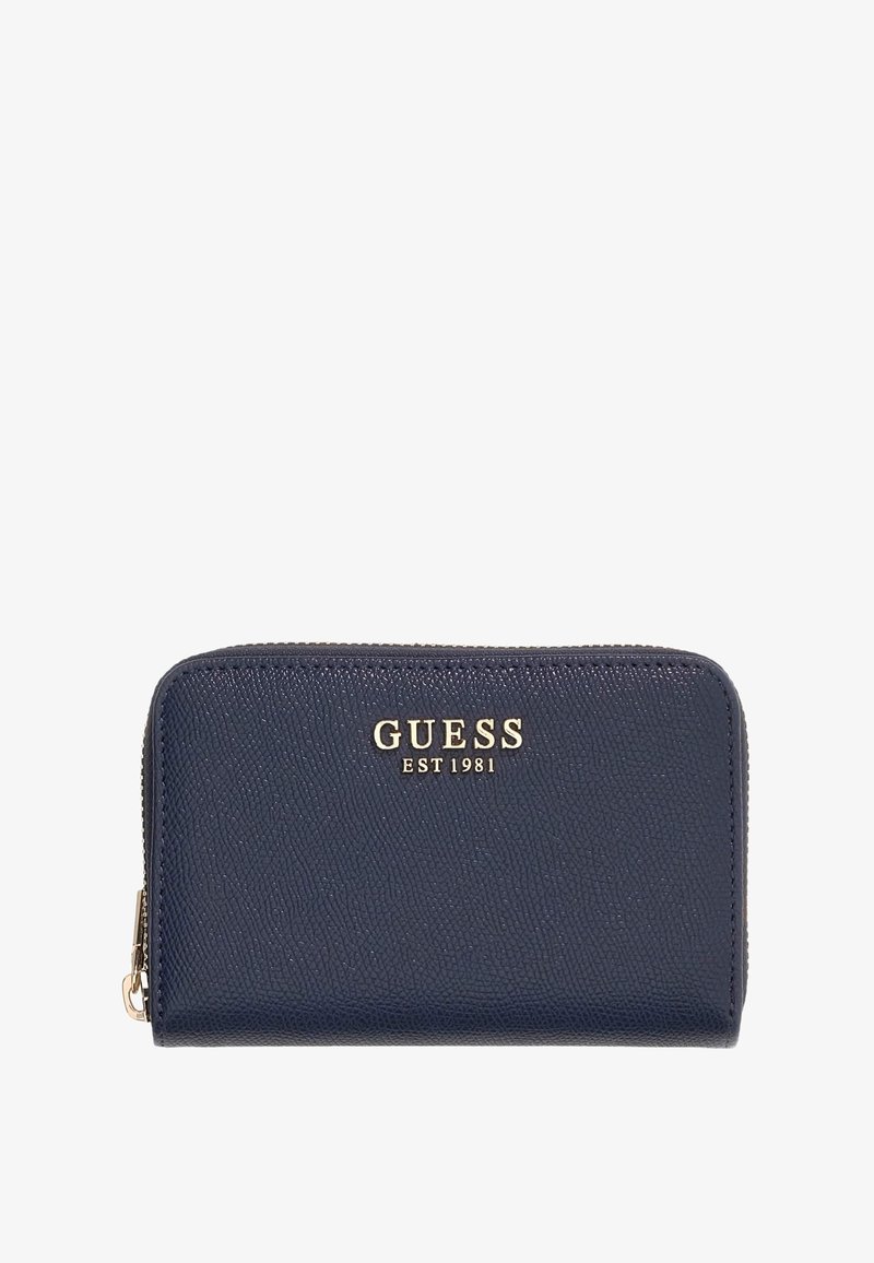 Portefeuille zippé Guess bleu marine avec surface texturée et logo doré "GUESS EST 1981" à l'avant.