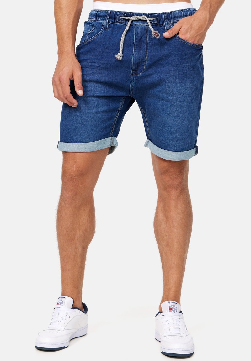 Dunkelblaue Jeansshorts für Männer mit umgeschlagenen Säumen, elastischem Taillenbund und Zugband. Verfügt über Fronttaschen und ein strukturiertes Gewebe.