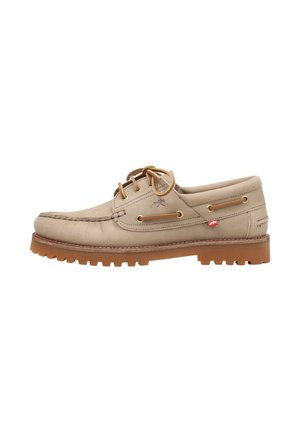 Zapato náutico de cuero beige con cordones marrones, ojales dorados, costura moc toe y suela gruesa de goma con surcos profundos para mayor agarre.