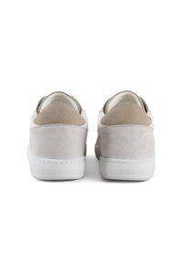 Zapatillas blancas y beige con un panel de ante texturizado en el talón, forma redondeada y suela de goma, que cuentan con un acabado suave y un diseño minimalista.