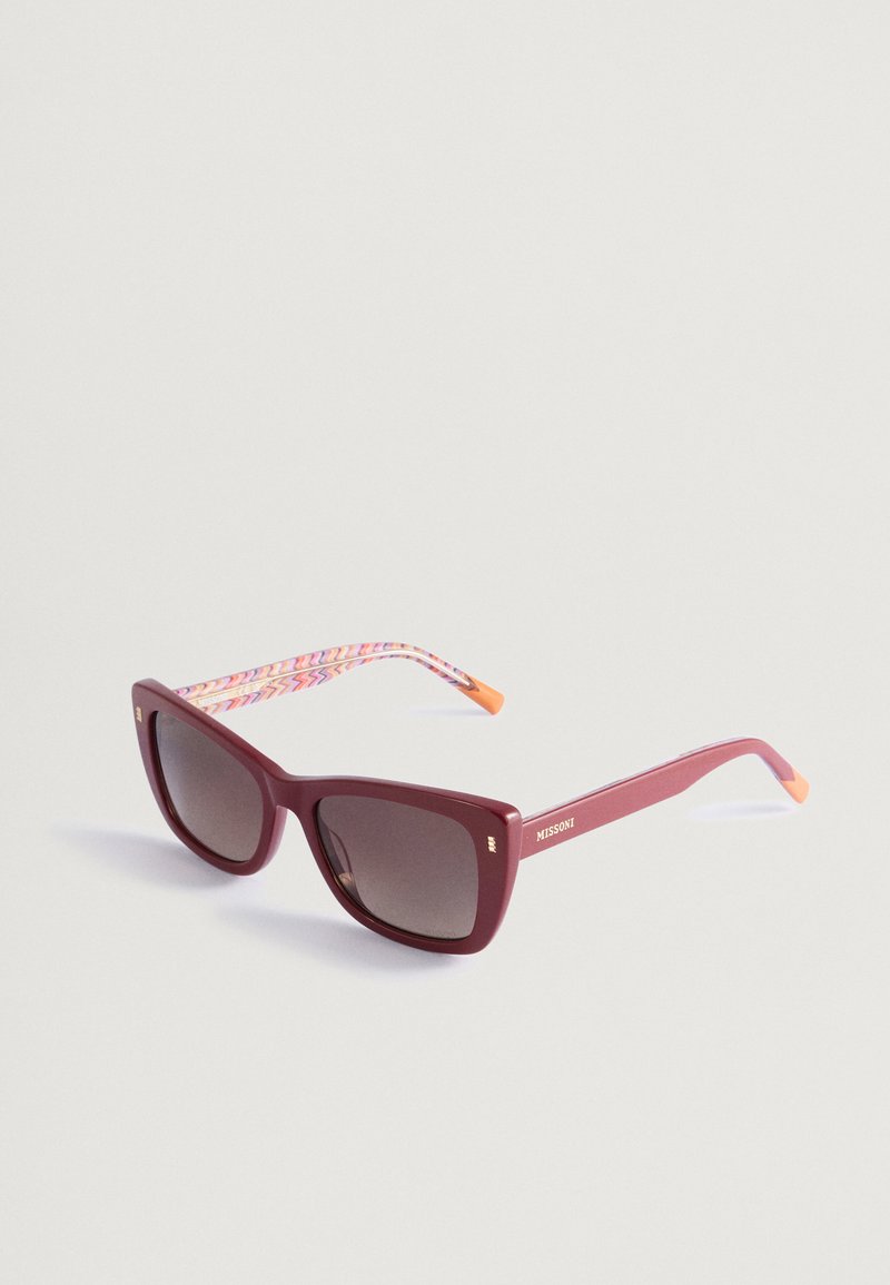 Óculos de sol retangulares burgundy com lentes escuras. As hastes apresentam um padrão zigzag colorido e pontas laranjas. Logótipo dourado da marca na lateral.
