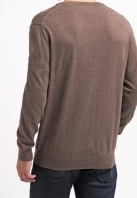 Pull marron à manches longues, avec un ourlet côtelé et un col rond. Le tissu semble lisse et légèrement texturé, avec un subtil éclat.