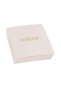 En fyrkantig, mjuk rosa låda med rundade hörn. Framsidan pryds av ordet "amor" i guld, centrerat och i ett modernt sans-serif typsnitt.